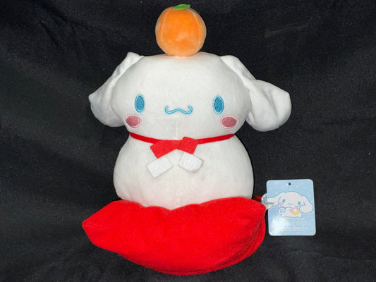 Cinnamon Roll Brand Plush Plushie Stuffie with Orange on Head Sitting on Red Pillow with Tags