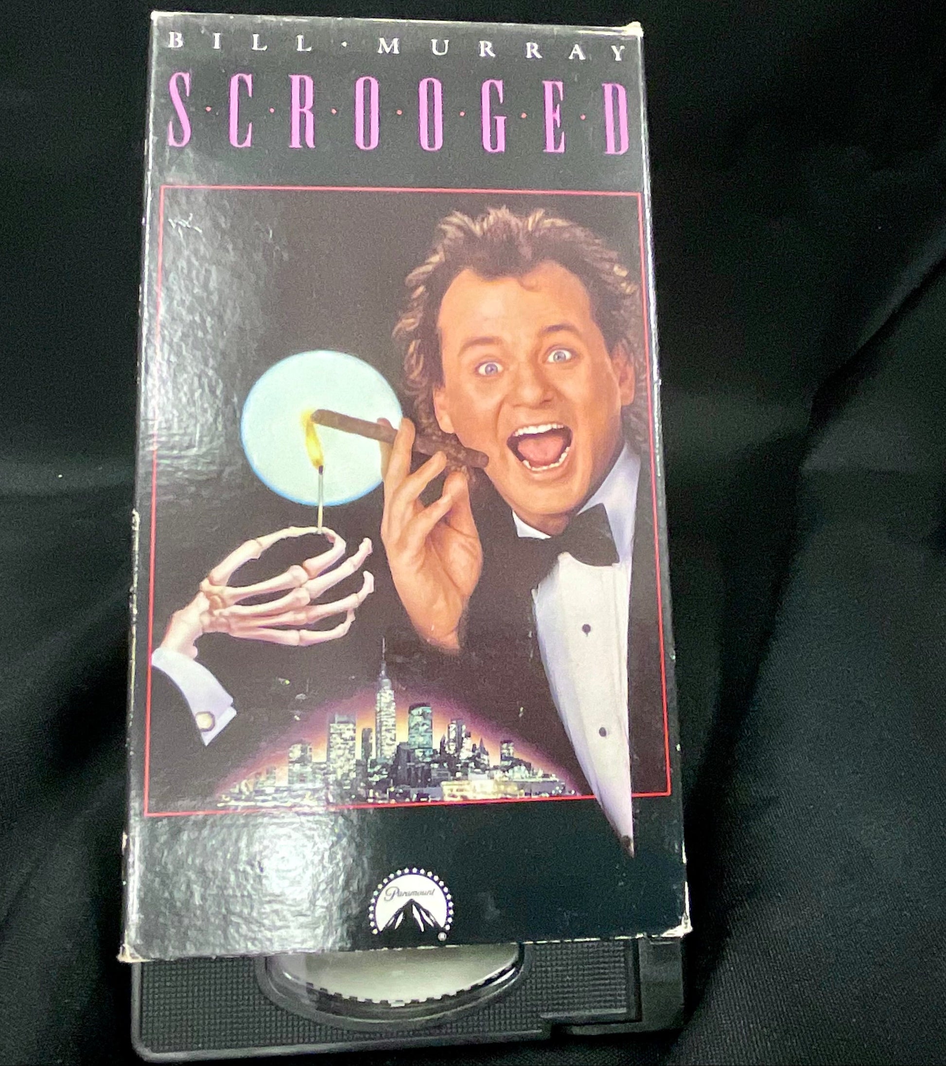 VHS tape of 'Scrooged' with Bill Murray on a black background