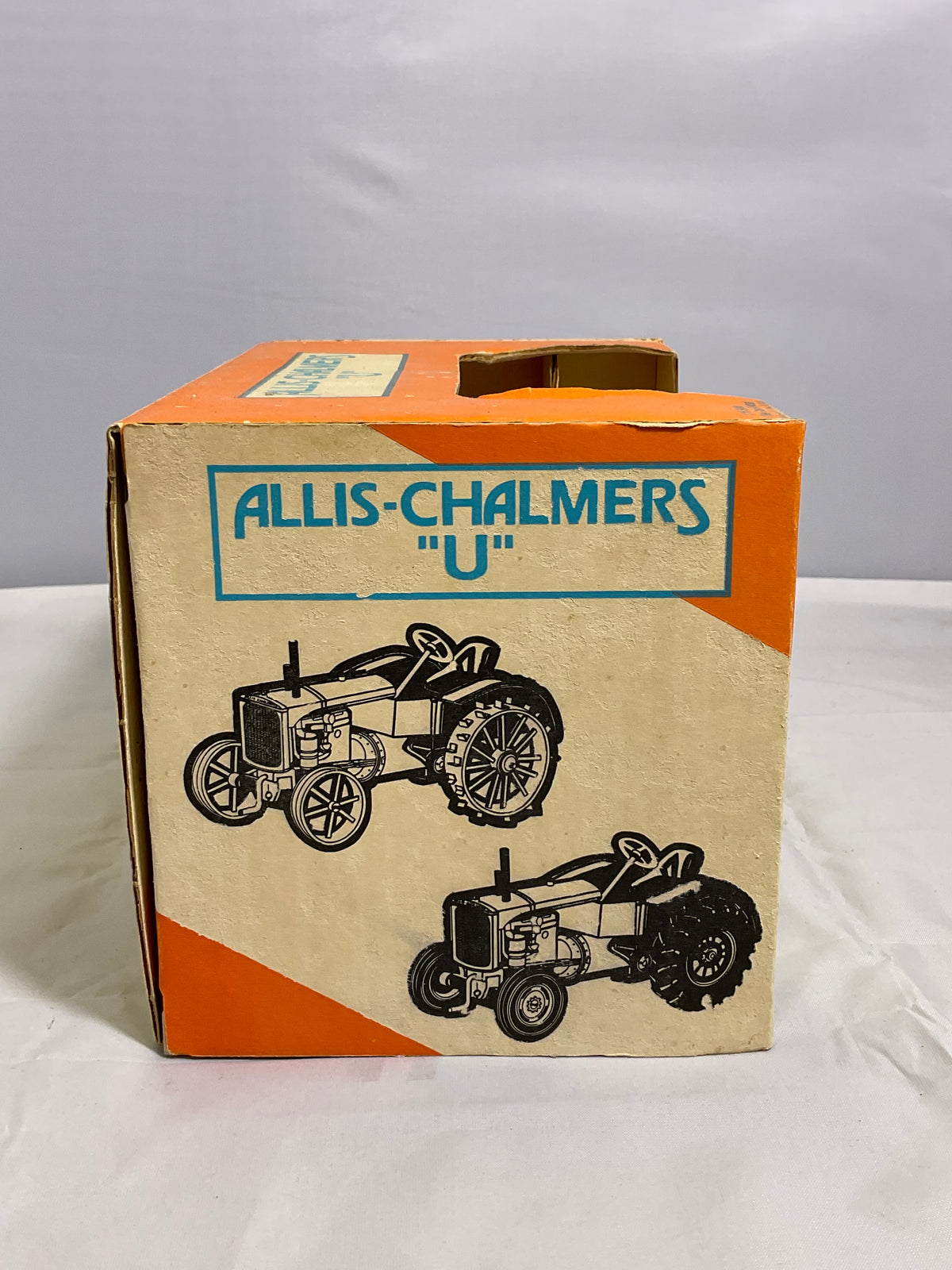 Cardboard box with Allis-Chalmers branding and tractor illustrations on a white background