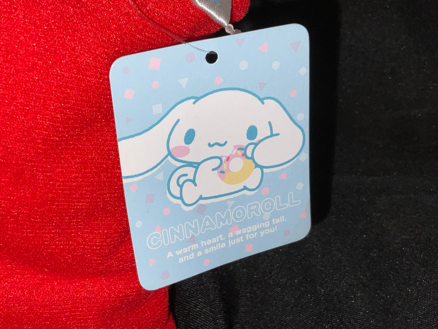 Cinnamon Roll Brand Plush Plushie Stuffie with Orange on Head Sitting on Red Pillow with Tags